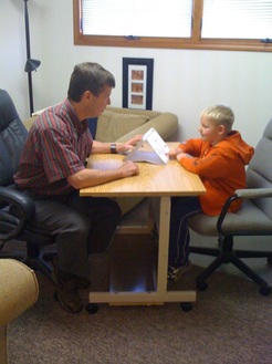 Photo of Dan Nolan PhD administering a test to a child